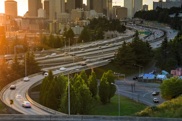 Busy traffic on I-5 Freeway at I-90 interchange during afternoon rush hour with Seattle skylines in...