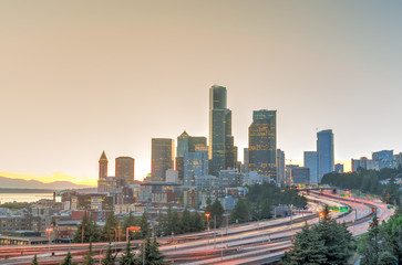 Seattle skylines and s-curved I-90, I-5 highway interchange traffic motion during sunset. Travel...