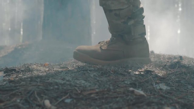 Close-up shot of a soldier's boot running in the smoky forest