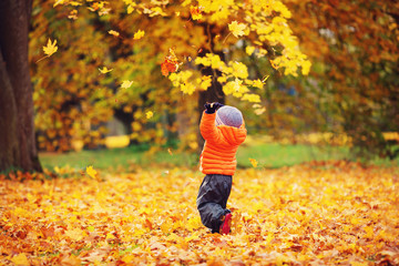 Child standing with umbrella in beautiful autumnal day