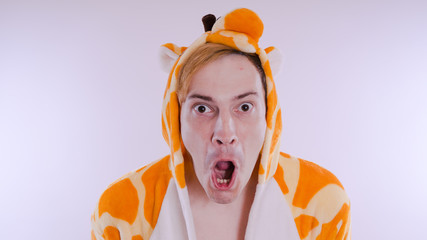 guy in a bright children's pajamas in the form of a kangaroo, on white background. emotional...