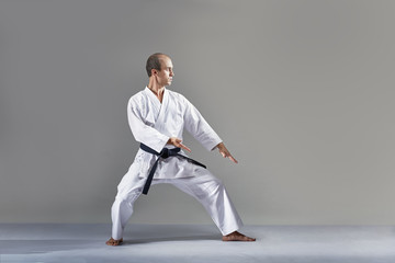 Sportsman in a white karategi performs a formal karate exercise