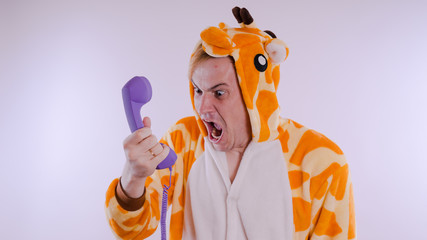 guy in a bright children's pajamas in the form of a kangaroo, on white background. emotional...