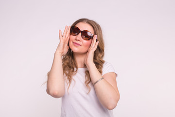Fashion, style and people concept - Attractive young woman wearing sunglasses over white background