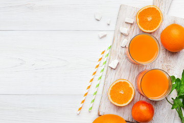Fresh orange juice with fruits on wooden table