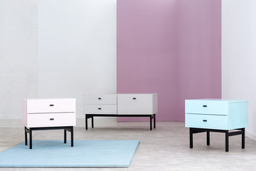 Three pastel cabinets set in a room interior with white and pink wall. Real photo. Place your graphic