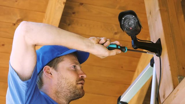 cctv technician installing surveillance camera in the house carport