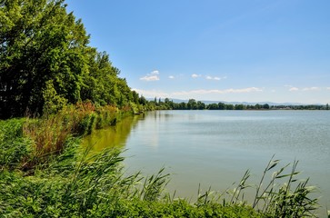 Daily springtime landscape. Beautiful lake with mountains in the background.