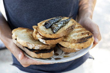 man with a plate of bread and sardines