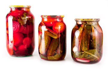 Canned tomatoes and cucumbers in a glass jar on a white background