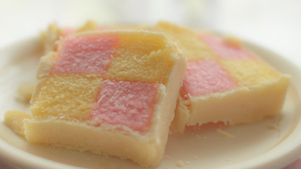 Close up of Battenberg cake D, light sponge cake with the pieces covered in jam, shallow depth of field food photography