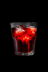 Monochrome transparent cocktail, refreshing in a low glass with a lot of ice cubes with taste of berries, cherries, strawberries, grapefruit. Side view Isolated black background. Drink for the menu