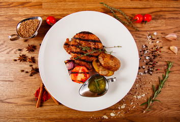  Grilled meat whale in a white plate on the table, with many condiments and salads.