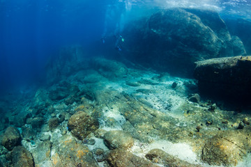 SCUBA divers exploring beautiful underwater scenery in a clear, tropical ocean