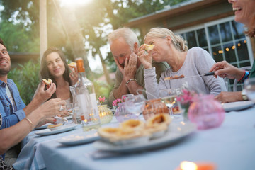 Friends enjoying summer barbecue dinner in garden