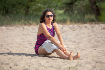 Fototapeta na wymiar Girl with a towel on the sand on the beach