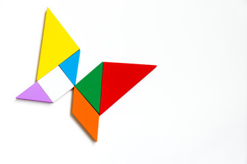 Fototapeta na wymiar Colorful wood tangram puzzle in butterfly shape on white background