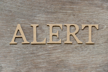 Alphabet letter in word alert on wood background