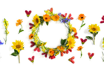 Naklejka premium Wreath of summer wildflowers sunflowers, flowers calendula, linaria, blue cornflowers, red samaras maple ash on white background with space for text. Top view, flat lay