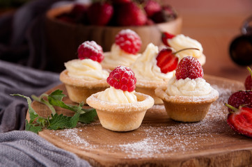 Tartlets with cream, raspberries, strawberries.