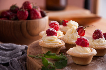 Tartlets with cream, raspberries, strawberries.