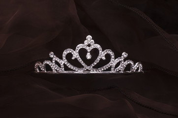 silver diadem with heart and diamonds isolated on the fabric © vitaly tiagunov