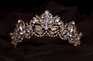 gold diadem with diamonds isolated on the fabrick