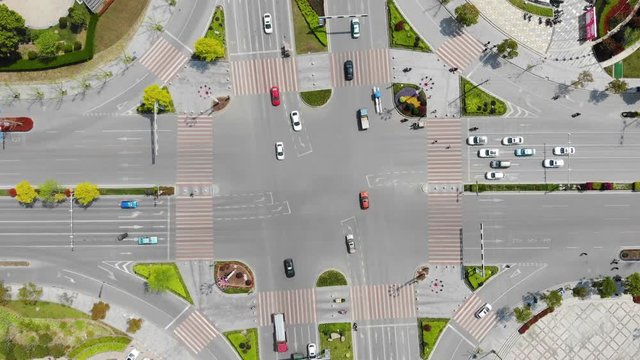 Time lapse of suburban intersection from above. Modern green traffic crossing from aerial drone in Jiashan, China. Cars, trucks and scooters crossing a busy traffic light on a beautiful summer day.