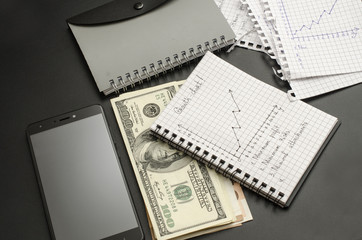 Fototapeta premium notepad with growth chart, pen, money and cellphone