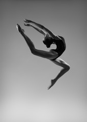 Flexible girl in a jump. Black and white photo.