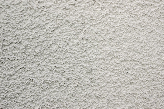white lime plaster texture wall of a building, wallpaper backdrop , space for text