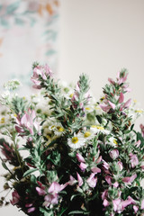 Fototapeta na wymiar colorful amazing wildflowers in vase on background of rustic room