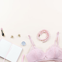 Fashion blogger workspace with woman elegant pink lace bra and panties, pumps and note book. Stylish lingerie flat lay.