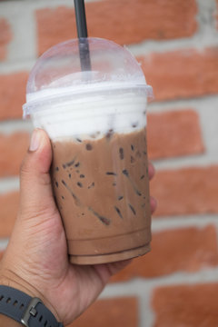 Iced mocha in takeaway cup on hand