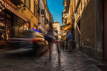 aosta city center street road people walk fast for shopping with a police car intrusion © Michele