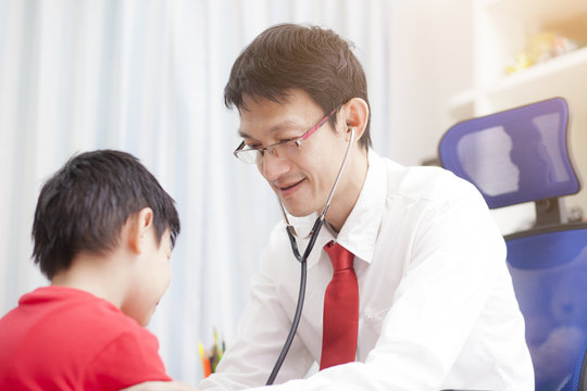 Portrait Of Proud Doctor With Stethoscope.doctor Examining A Child Patient By Stethoscope..