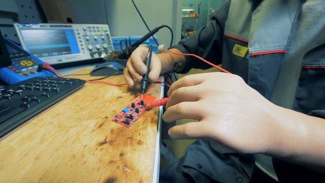 Man with prosthetic hands is soldering a microscheme