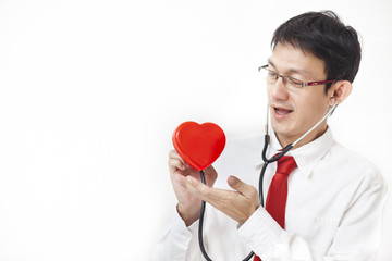 cardiologist checking red heart with stethoscope. cardiology concept.on white backround.