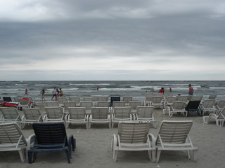 transats blancs et plage un jour d'orage