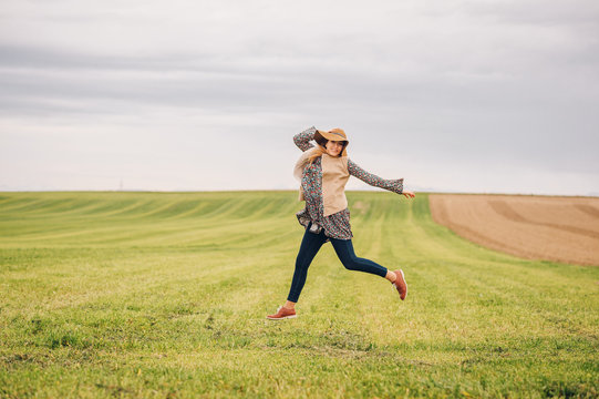 Outdoor lifestyle portrait of young happy woman posing in countryside