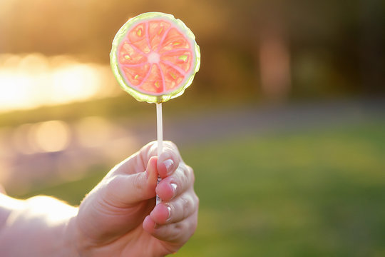 close up lollipop in child hand in park