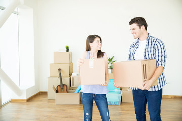 Fototapeta na wymiar Smiling Couple Moving Boxes In New Home