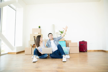 Couple Doing Online Shopping Using Laptop In New House