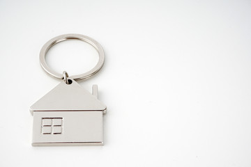 Key and keychain in the shape of a house isolated on white background.