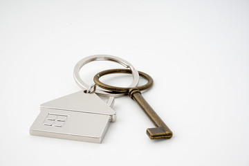 Key and keychain in the shape of a house isolated on white background.