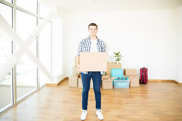 Fototapeta na wymiar Owner With Moving Box Standing In Newly Purchased House