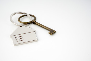 Key and keychain in the shape of a house isolated on white background.
