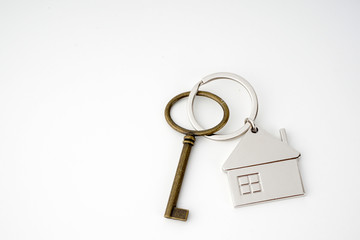 Key and keychain in the shape of a house isolated on white background.