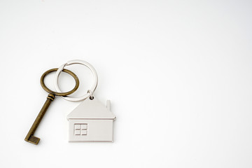 Key and keychain in the shape of a house isolated on white background.