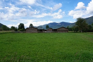 Granja en la montaña y campo verde